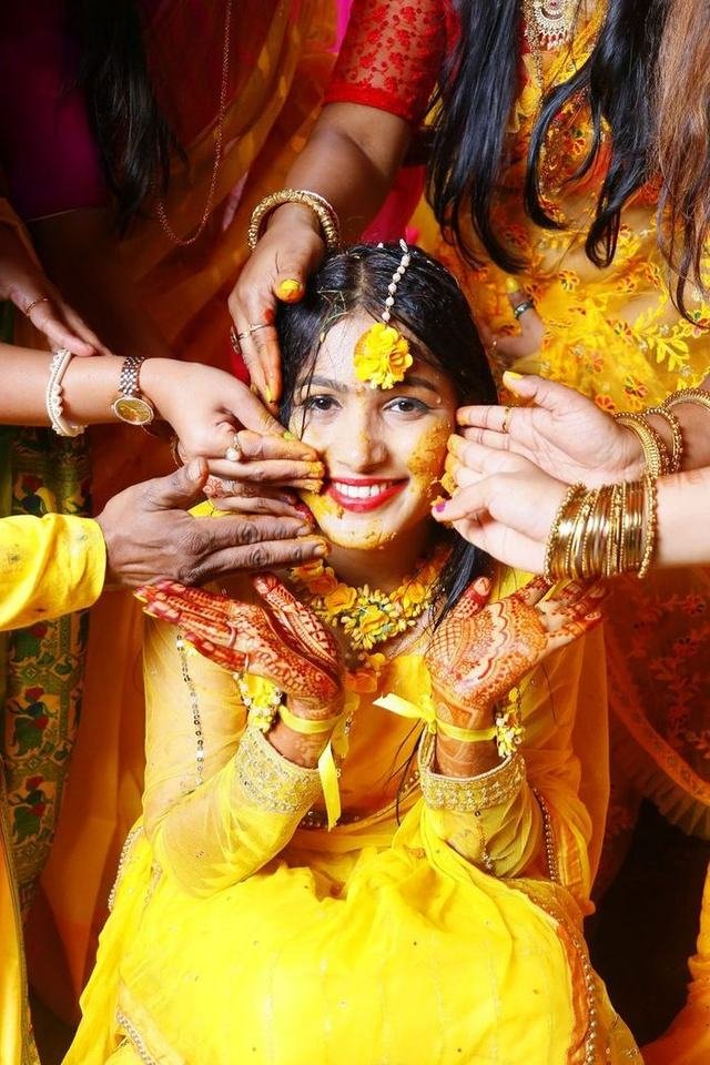 Artist applying henna on the brides hands